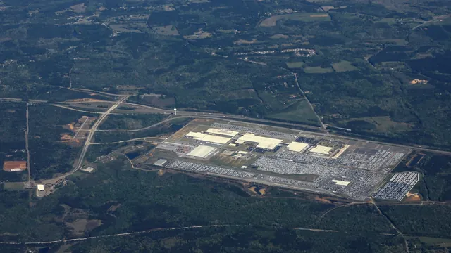 Aerial view of a large car assembly plant and its vehicle lots surrounded by Georgia pine forest
