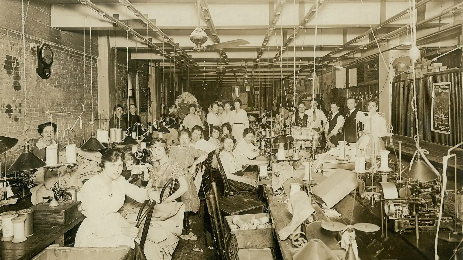 Rows of seamstresses work at sewing machines in a large, bright garment workshop in St. Louis in 1919