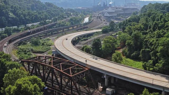 Blast furnace and mill buildings of the Edgar Thomson Steel Works beside a road and a creek in Braddock, Pennsylvania