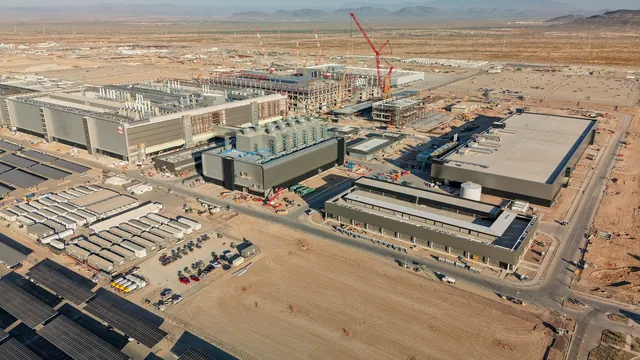 Large semiconductor factory buildings under construction with cranes against a desert sky in Phoenix, Arizona