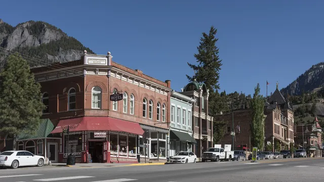 Locally owned shops in historic brick buildings along Main Street in Ouray, Colorado, below the San Juan Mountains
